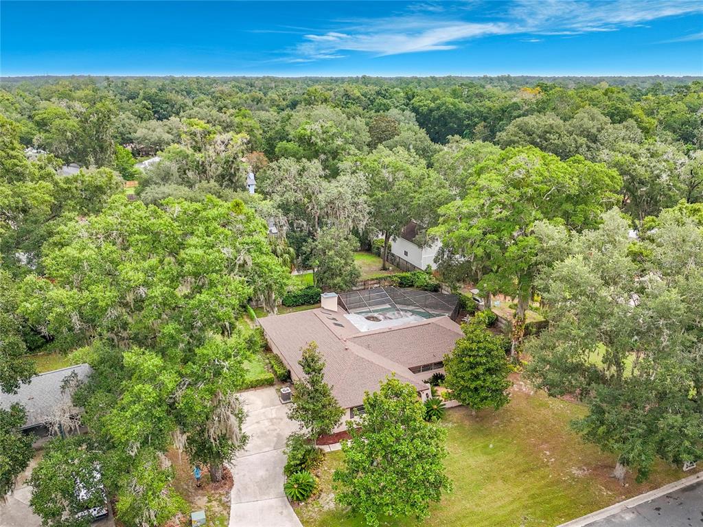 An aerial view shows a single-story house with a screened pool and a large driveway — 3944 NW 40TH COURT, GAINESVILLE, FL