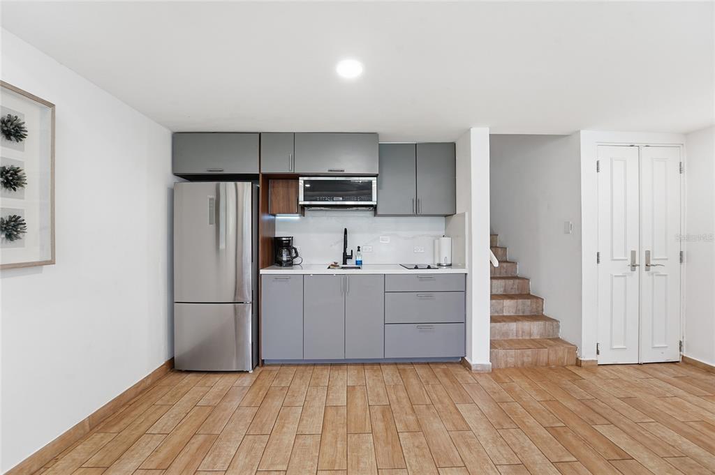 A kitchen with gray cabinets, stainless steel appliances, and wood-look tile flooring — 83 BEACH VILLAGE DR UNIT 83, HUMACAO, PR