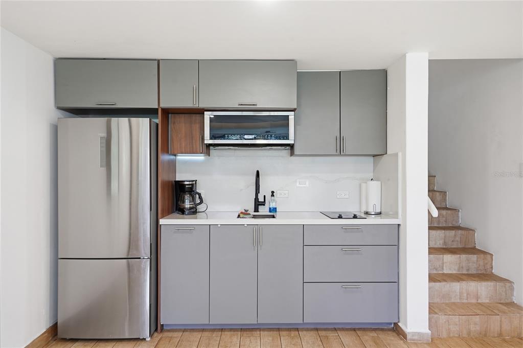 A small kitchen features gray cabinets, stainless steel appliances, and a white countertop — 83 BEACH VILLAGE DR UNIT 83, HUMACAO, PR