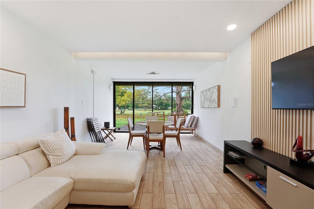 A living and dining area features tile flooring, a white sectional, and a slatted wall — 83 BEACH VILLAGE DR UNIT 83, HUMACAO, PR
