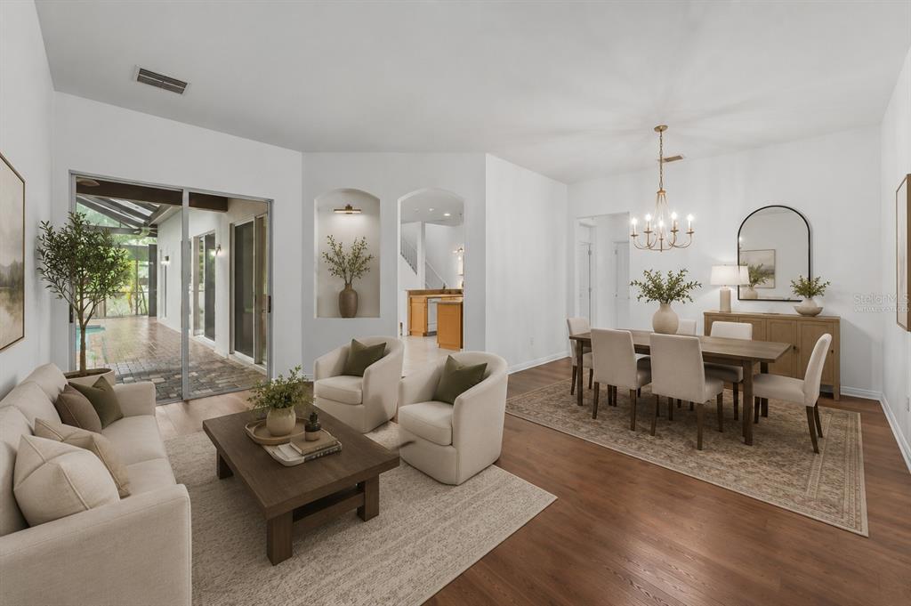 A living and dining room with white walls, hardwood floors, and a sliding glass door — 2041 HEARTLAND CIRCLE, VALRICO, FL