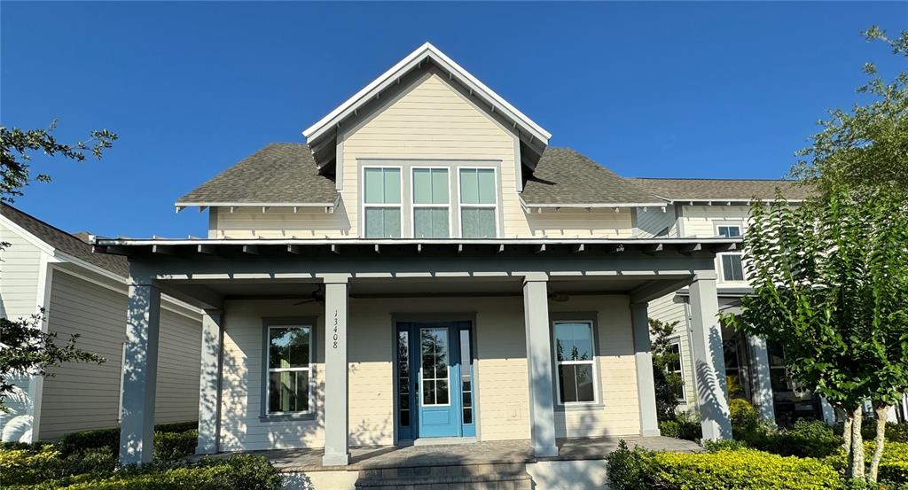 A two-story house features a front porch, blue door, and light-colored horizontal siding — 13408 BEEBE ALLEY, ORLANDO, FL