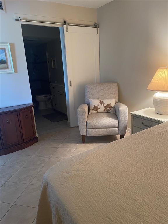 A kitchen features white cabinets, light stone countertops, and a blue-green subway tile backsplash — 6104 PALMA DEL MAR BOULEVARD S UNIT 304, ST PETERSBURG, FL