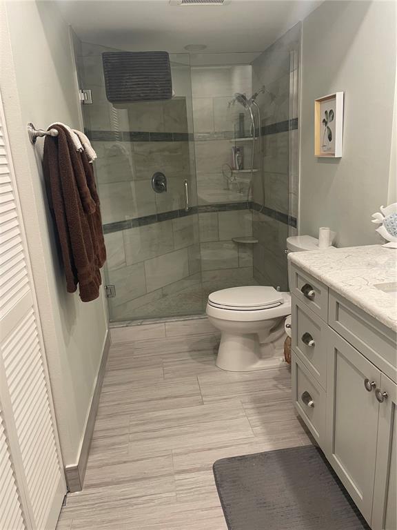 A kitchen area features white corner cabinets, a rolling cart, and a stainless steel refrigerator — 6104 PALMA DEL MAR BOULEVARD S UNIT 304, ST PETERSBURG, FL