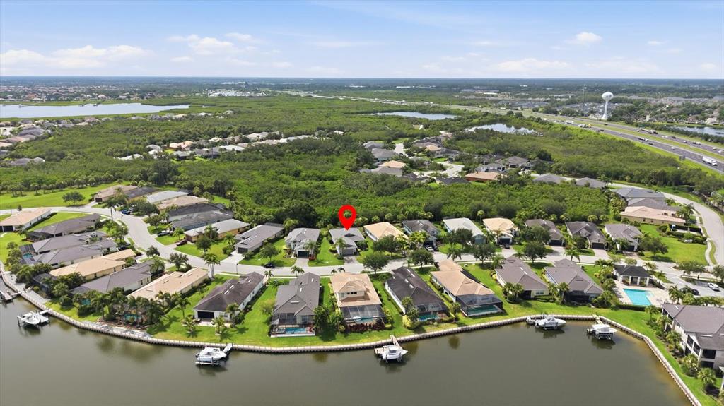 An aerial view shows a residential neighborhood with houses along a waterfront — 5029 LAKE OVERLOOK AVENUE, BRADENTON, FL