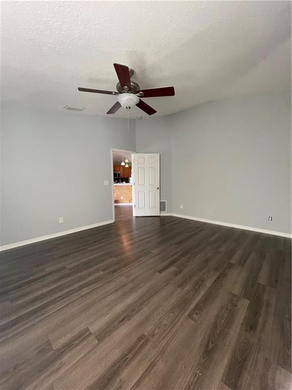 A room with light gray walls, dark wood-look flooring, and a ceiling fan — 1435 9th Place, Vero Beach FL 32960, VERO BEACH, FL