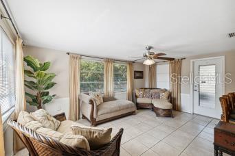 A sunroom with tile floors, wicker furniture, a ceiling fan, and large windows — 4408 RUDDER WAY, NEW PORT RICHEY, FL