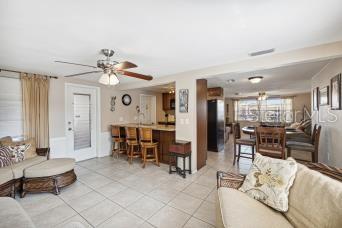 An open-concept living room and kitchen area with tile flooring and a ceiling fan — 4408 RUDDER WAY, NEW PORT RICHEY, FL