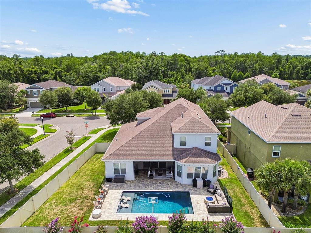 An aerial view of a two-story house with a backyard pool and patio — 8908 BELLA VITA CIRCLE, LAND O LAKES, FL