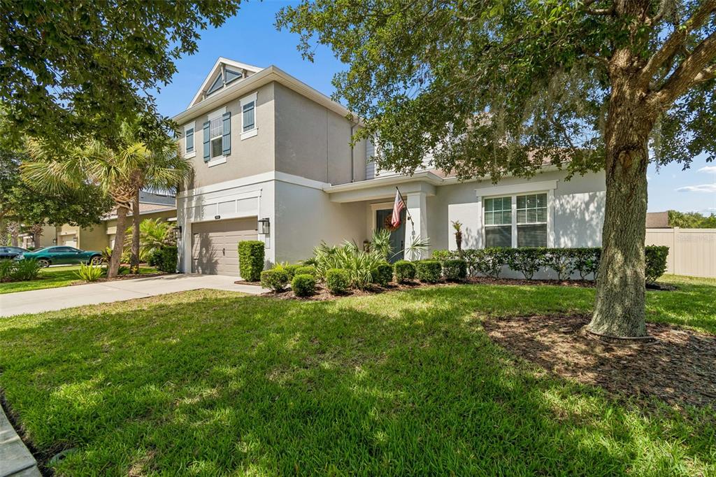 A two-story suburban house with a gray exterior, a garage, and a front lawn — 8908 BELLA VITA CIRCLE, LAND O LAKES, FL