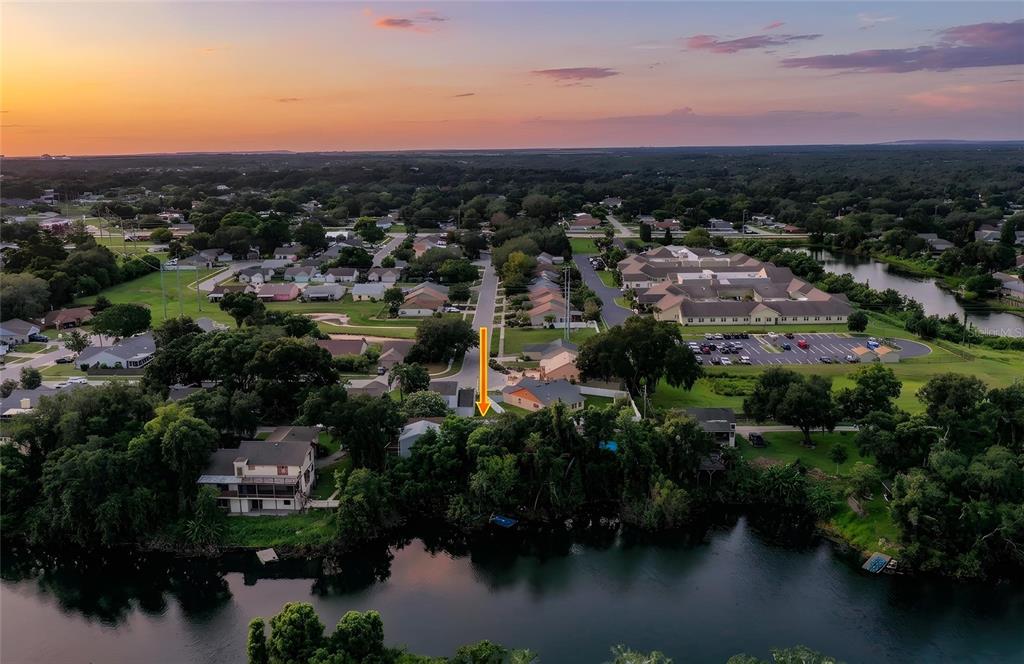 An aerial view shows a residential property marked by an arrow near a lake — 950 LAKE COVE TRAIL, LAKELAND, FL