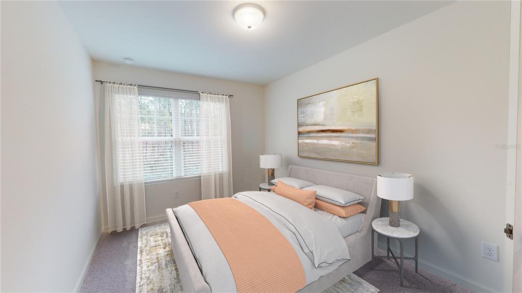 A bedroom features a bed with peach bedding, two bedside tables, and a large wall painting — 14856 LUCCA WAY, DADE CITY, FL
