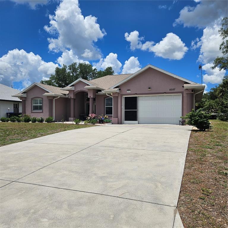 A single-story house with a concrete driveway, a two-car garage, and a covered entryway — 8357 DENARGO ROAD, NORTH PORT, FL