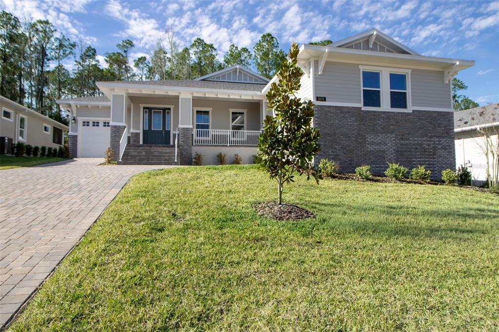 A single-story house features a gray brick facade, light siding, and a paved driveway — 3970 SOUTHERN VALLEY LOOP, BROOKSVILLE, FL