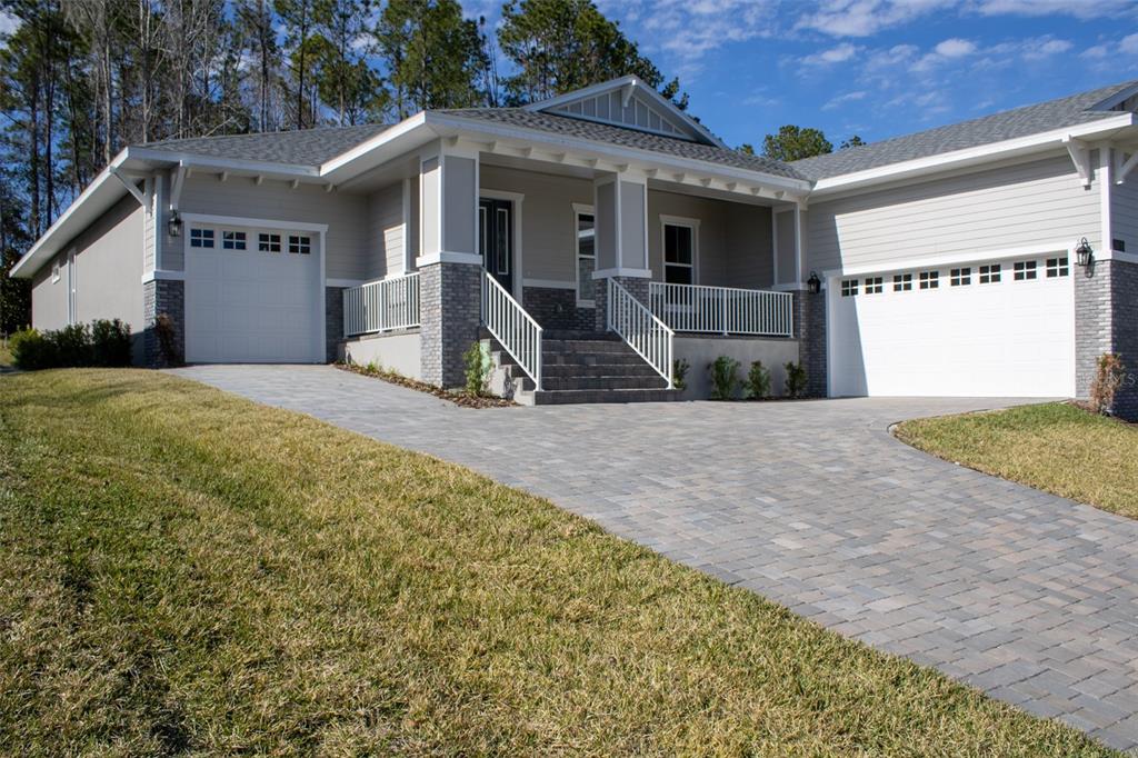 A single-story house with a paved driveway, two garage doors, and a covered front porch — 3970 SOUTHERN VALLEY LOOP, BROOKSVILLE, FL