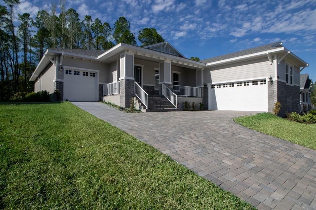 A single-story house with a paved driveway, two garage doors, and a covered front porch — 3970 SOUTHERN VALLEY LOOP, BROOKSVILLE, FL
