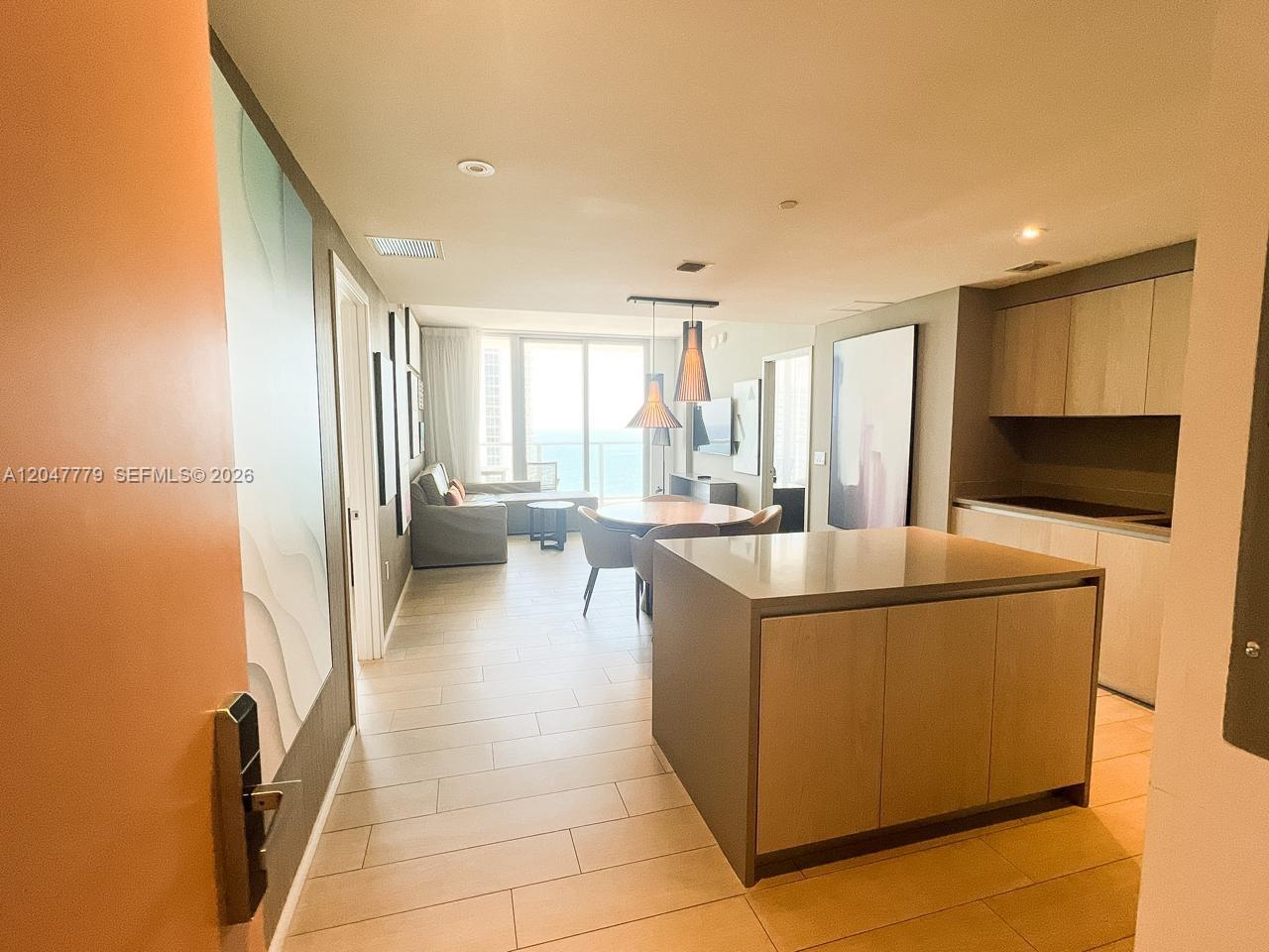 An open-concept condo interior features a kitchen island, dining area, and living space with ocean views — 4010 S Ocean Dr # T3505, Hollywood FL 33019, HOLLYWOOD, FL