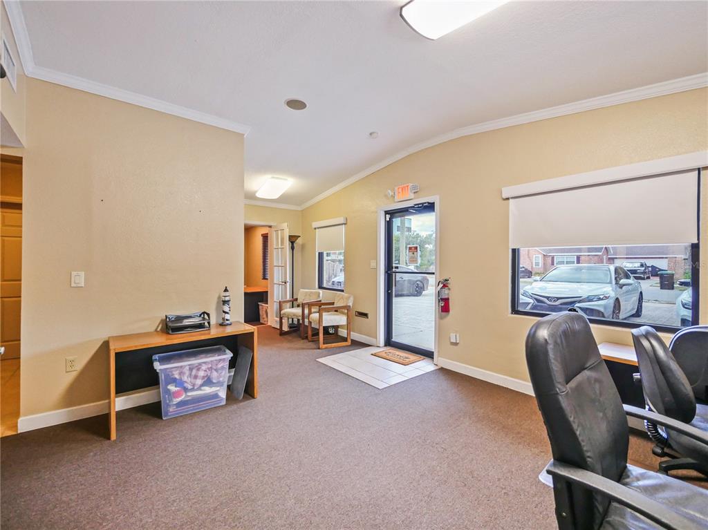 An office interior features beige walls, brown carpeting, a desk, two chairs, and a glass door — 4947 N PALM AVENUE, WINTER PARK, FL