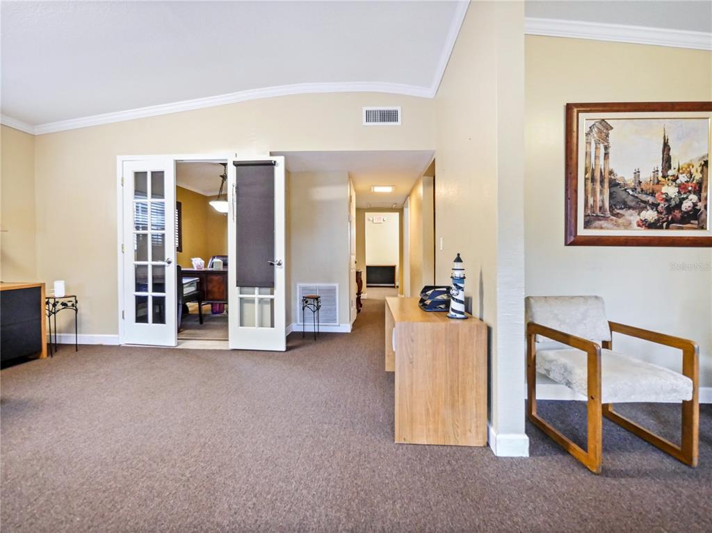 A carpeted living area features French doors opening to a dining room and a wooden chair — 4947 N PALM AVENUE, WINTER PARK, FL