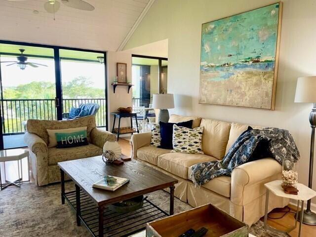 A living room features a beige sofa, a wooden coffee table, and large sliding glass doors — 1000 N Us Highway 1, Jupiter FL 33477, JUPITER, FL