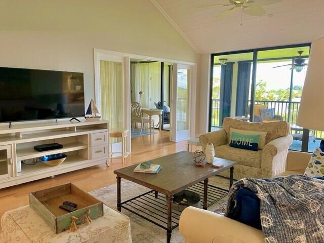 A living room features a large television, a wooden coffee table, and a screened porch — 1000 N Us Highway 1, Jupiter FL 33477, JUPITER, FL