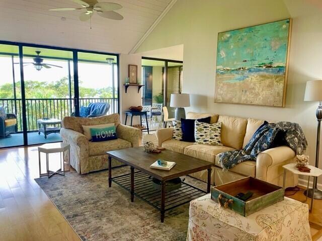 A living room features a beige sofa, patterned armchair, wooden coffee table, and large abstract art — 1000 N Us Highway 1, Jupiter FL 33477, JUPITER, FL