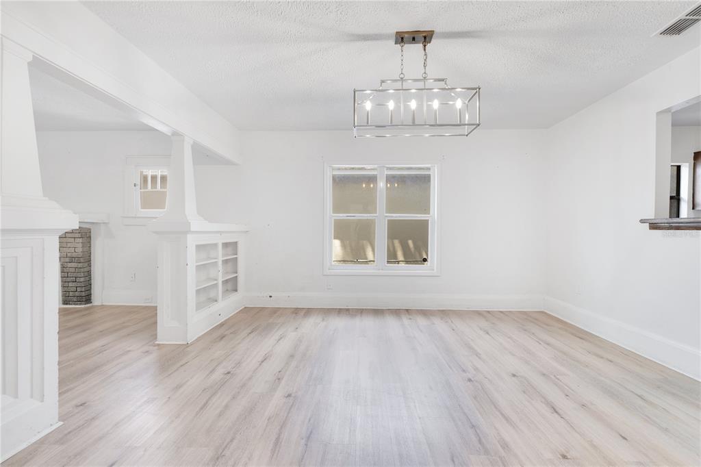 A bright dining room features white walls, light wood-look flooring, and a rectangular metal chandelier — 1029 COLYER STREET, ORLANDO, FL