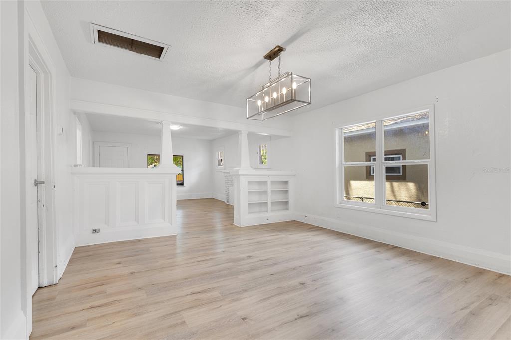 A bright dining room with white walls, light wood flooring, and a rectangular pendant light — 1029 COLYER STREET, ORLANDO, FL