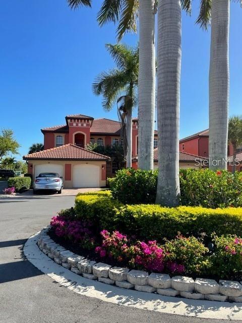 A multi-story house with a terracotta roof and a silver car in the driveway — 3500 MONDOVI COURT UNIT 811, PUNTA GORDA, FL