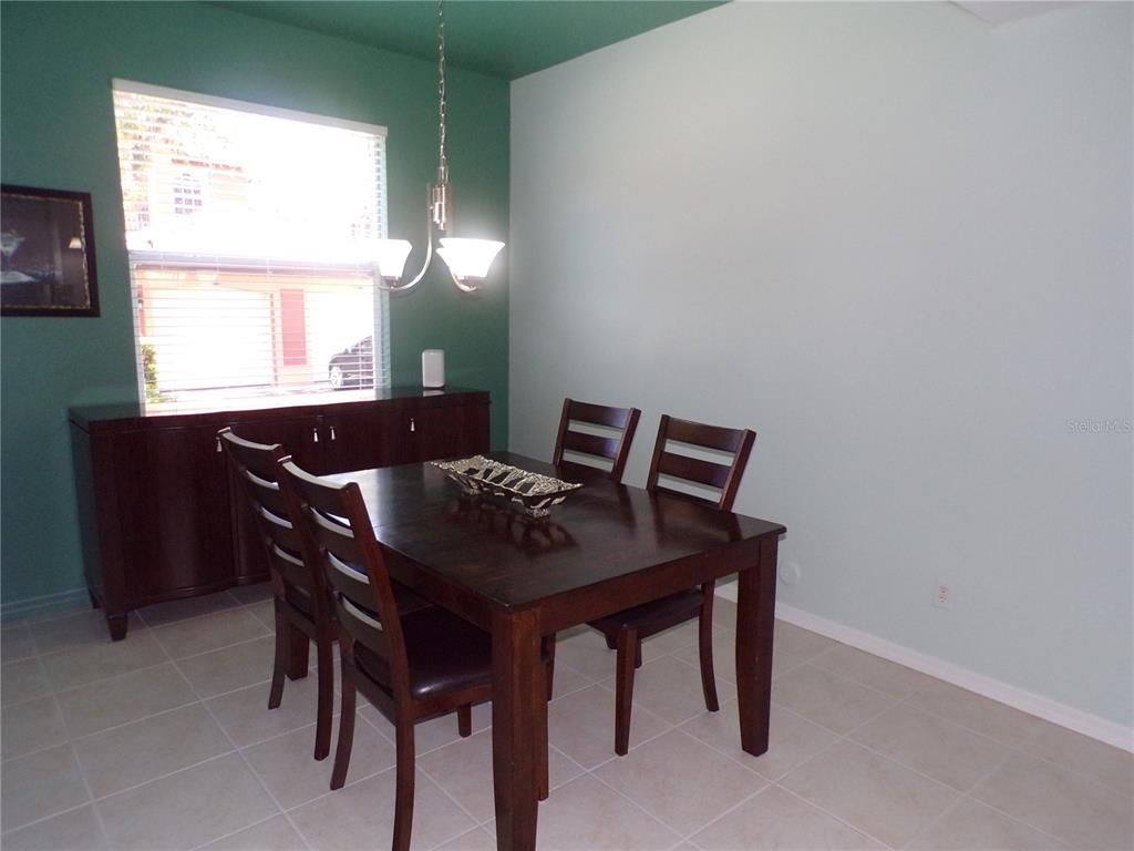 A dining room features a dark wood table and chairs, tile flooring, and two-toned walls — 3500 MONDOVI COURT UNIT 811, PUNTA GORDA, FL