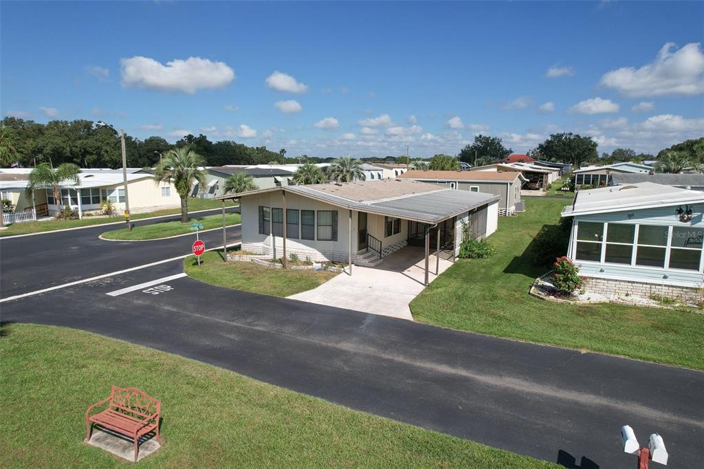An exterior view of a single-story mobile home with a carport and a paved street — 37605 AMIGO DRIVE, ZEPHYRHILLS, FL