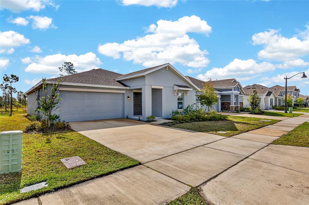 A single-story suburban house with a gray exterior, a two-car garage, and a concrete driveway — 2212 GREEN VALLEY STREET, DAYTONA BEACH, FL