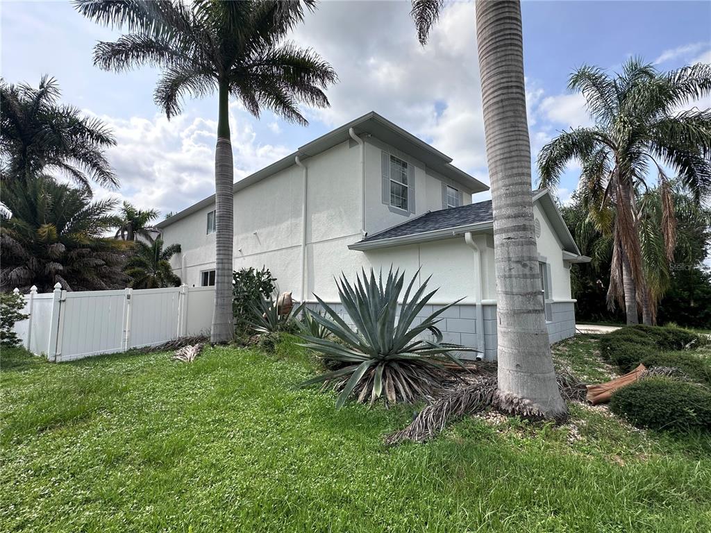A two-story house exterior with white stucco walls, a gray roof, and palm trees — 11116 HOFFNER EDGE DRIVE, RIVERVIEW, FL