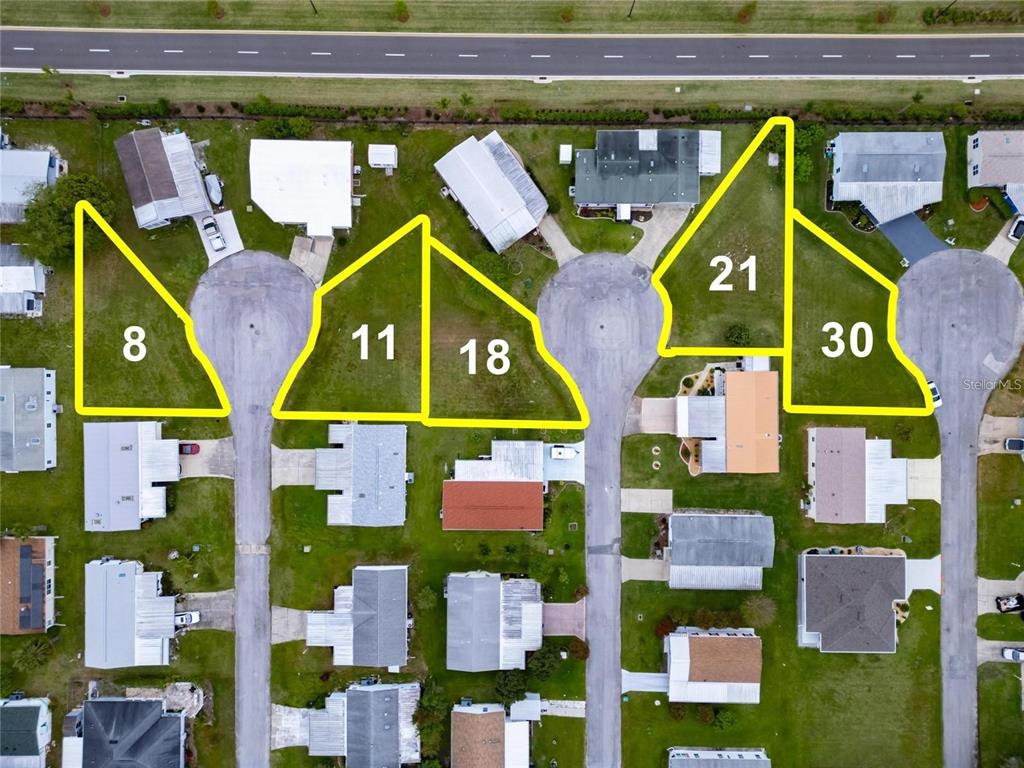 This aerial map shows several vacant residential lots highlighted in yellow within a neighborhood — LOT 8 BLK C LIBERTY COURT, WILDWOOD, FL
