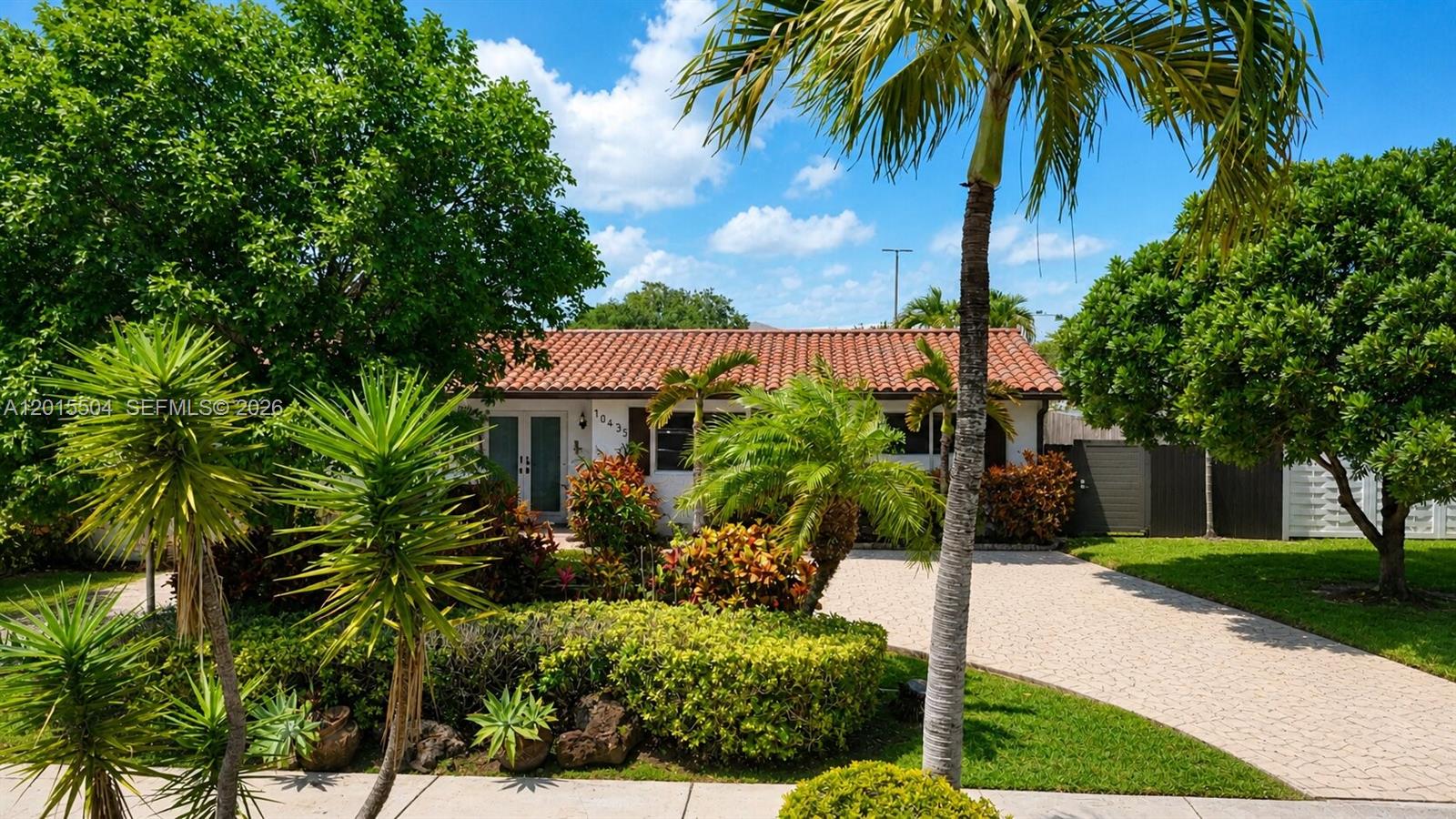 A single-story house with a terracotta tile roof and a paved driveway surrounded by landscaping — 10435 SW 92nd St, Miami FL 33176, MIAMI, FL