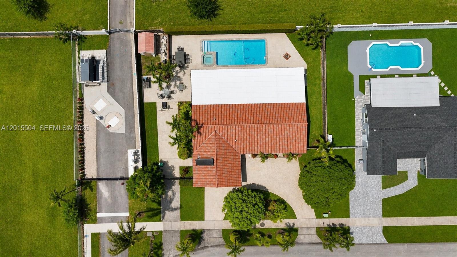 An aerial view shows a house with a red tile roof, pool, and paved driveway — 10435 SW 92nd St, Miami FL 33176, MIAMI, FL