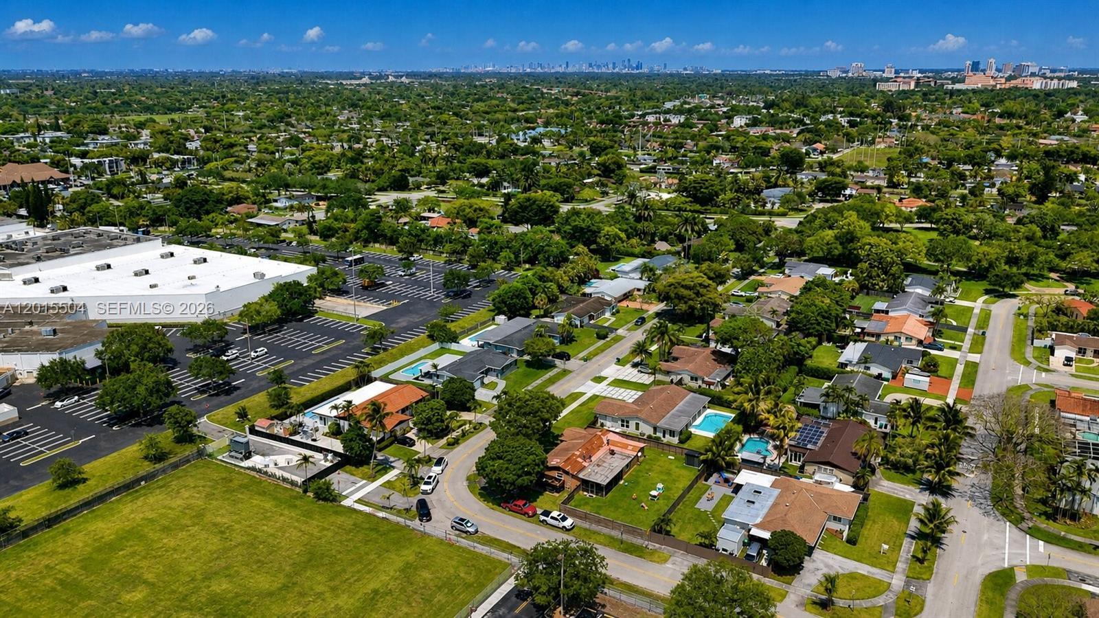 An aerial view shows a residential neighborhood with houses, swimming pools, and a large parking lot — 10435 SW 92nd St, Miami FL 33176, MIAMI, FL