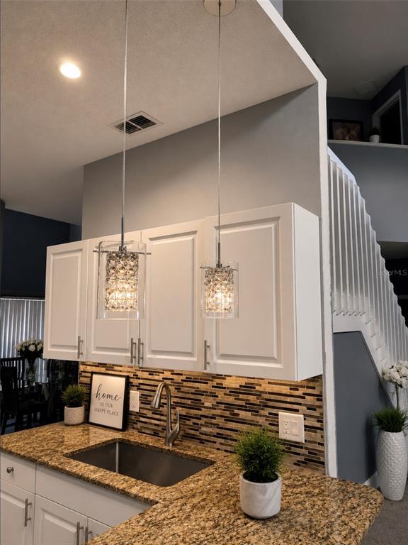 An elevated view of a living and dining area with neutral furniture and tile flooring — 292 BECKENHAM DRIVE, KISSIMMEE, FL