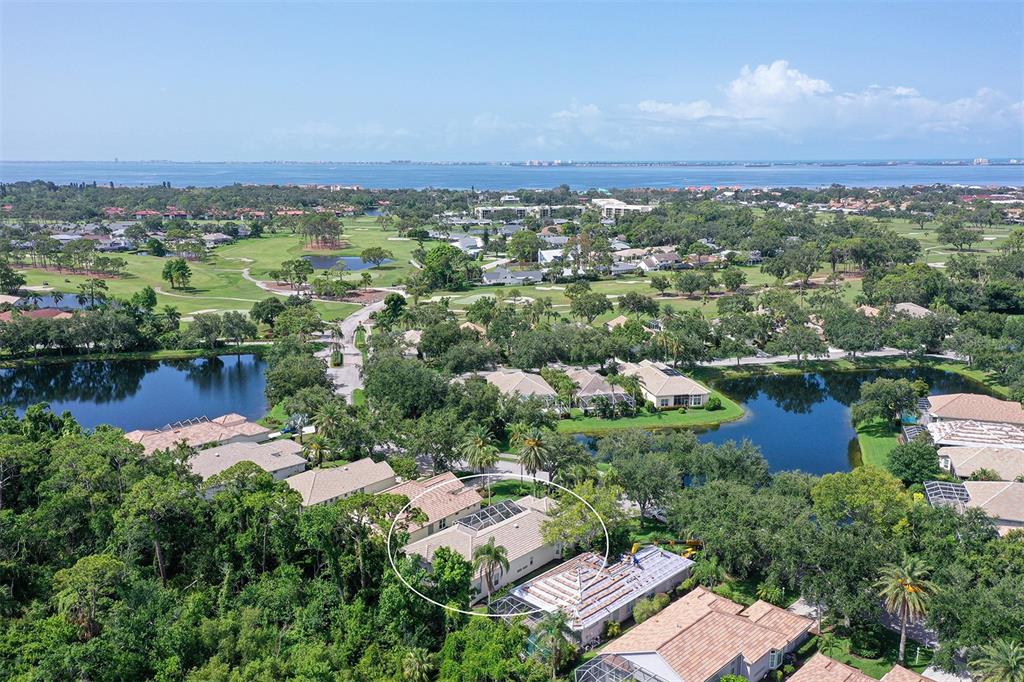 An aerial view shows a residential neighborhood with houses, ponds, and a golf course — 5839 LOS VERDES COURT, BRADENTON, FL