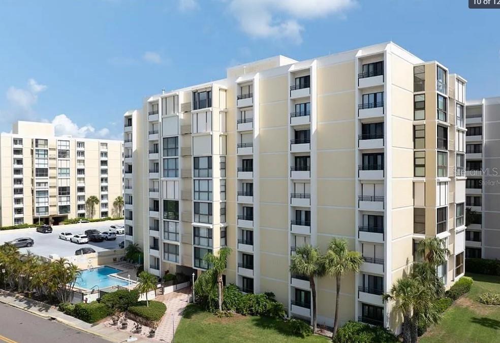 An exterior view of a multi-story apartment building with a swimming pool and parking lot — 830 S GULFVIEW BOULEVARD UNIT 601, CLEARWATER BEACH, FL