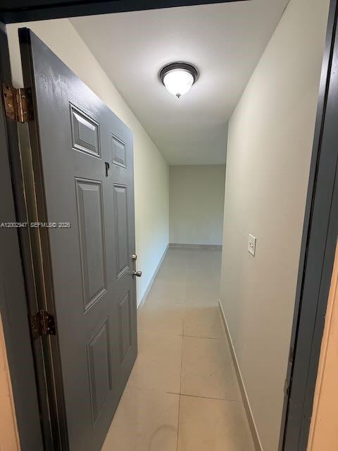 A gray door with a letter P opens into a narrow hallway with tiled floors — 939 Magnolia DRIVE # L, Lake Park FL 33403, LAKE PARK, FL