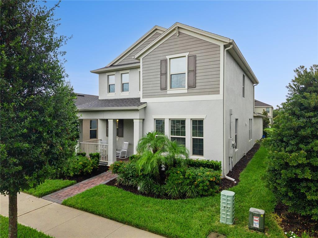 A two-story house with a light-colored stucco exterior, gray siding, and a front porch — 9462 KOMIKA LANE, WINTER GARDEN, FL