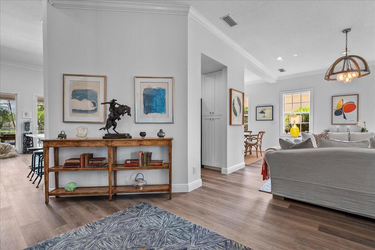 A living area features a wooden console table, gray sofa, and light wood flooring — 8465 Belize Place, Wellington FL 33414, WELLINGTON, FL