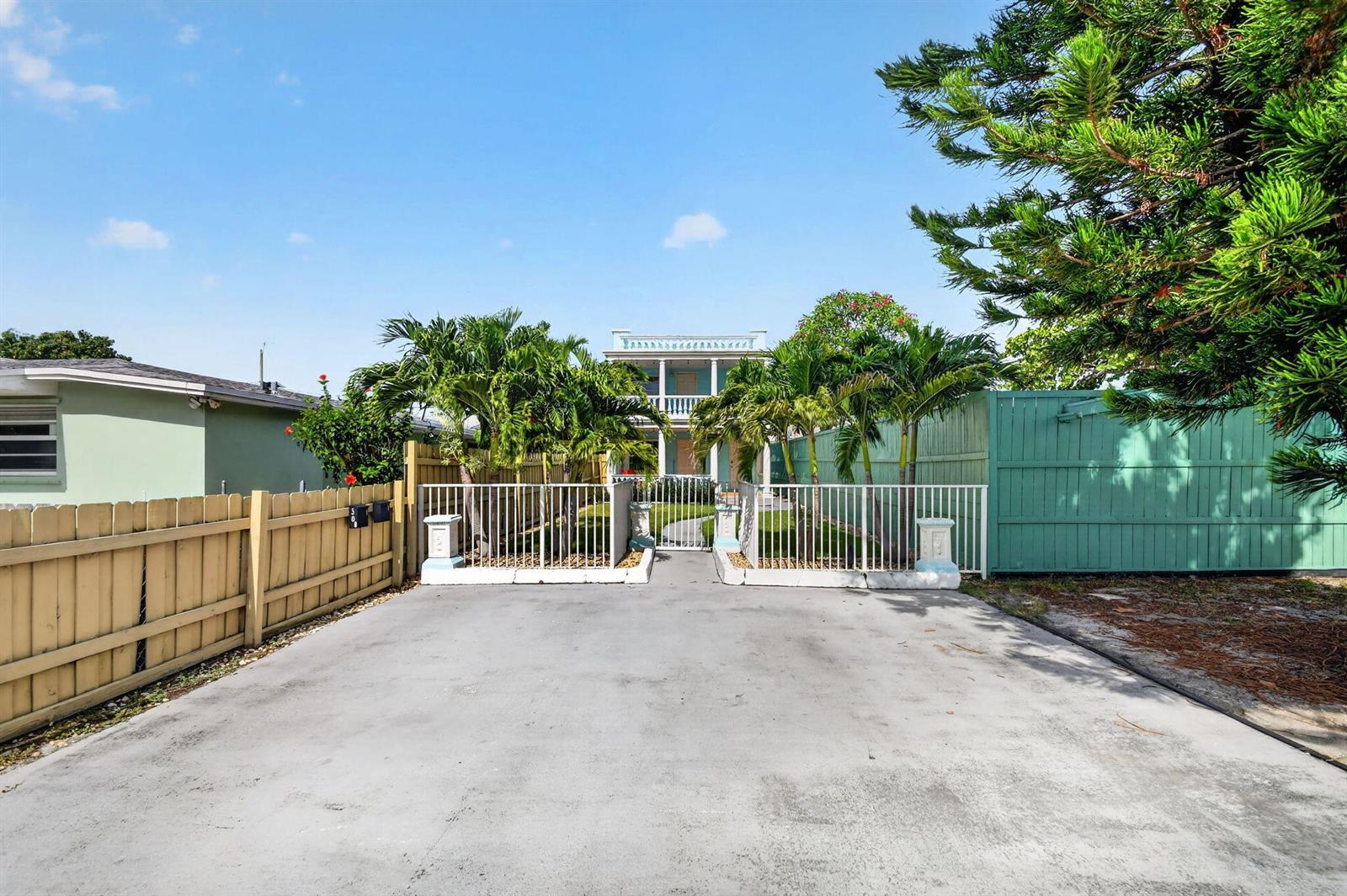 A paved driveway leads to a gated entrance and a two-story house with palm trees — 508 N K Street # 1, FL 33460, FL