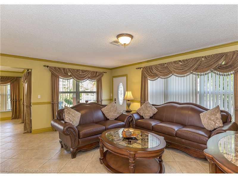 A living room features two brown leather sofas, a glass-topped coffee table, and tiled floors — 160 SE 12th Street, Pompano Beach FL 33060, POMPANO BEACH, FL