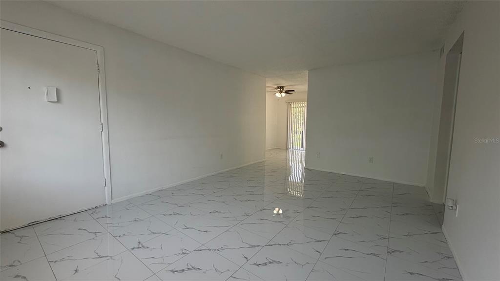 An empty room with white walls and white marble-patterned tile flooring — 5325 CURRY FORD ROAD UNIT D206, ORLANDO, FL