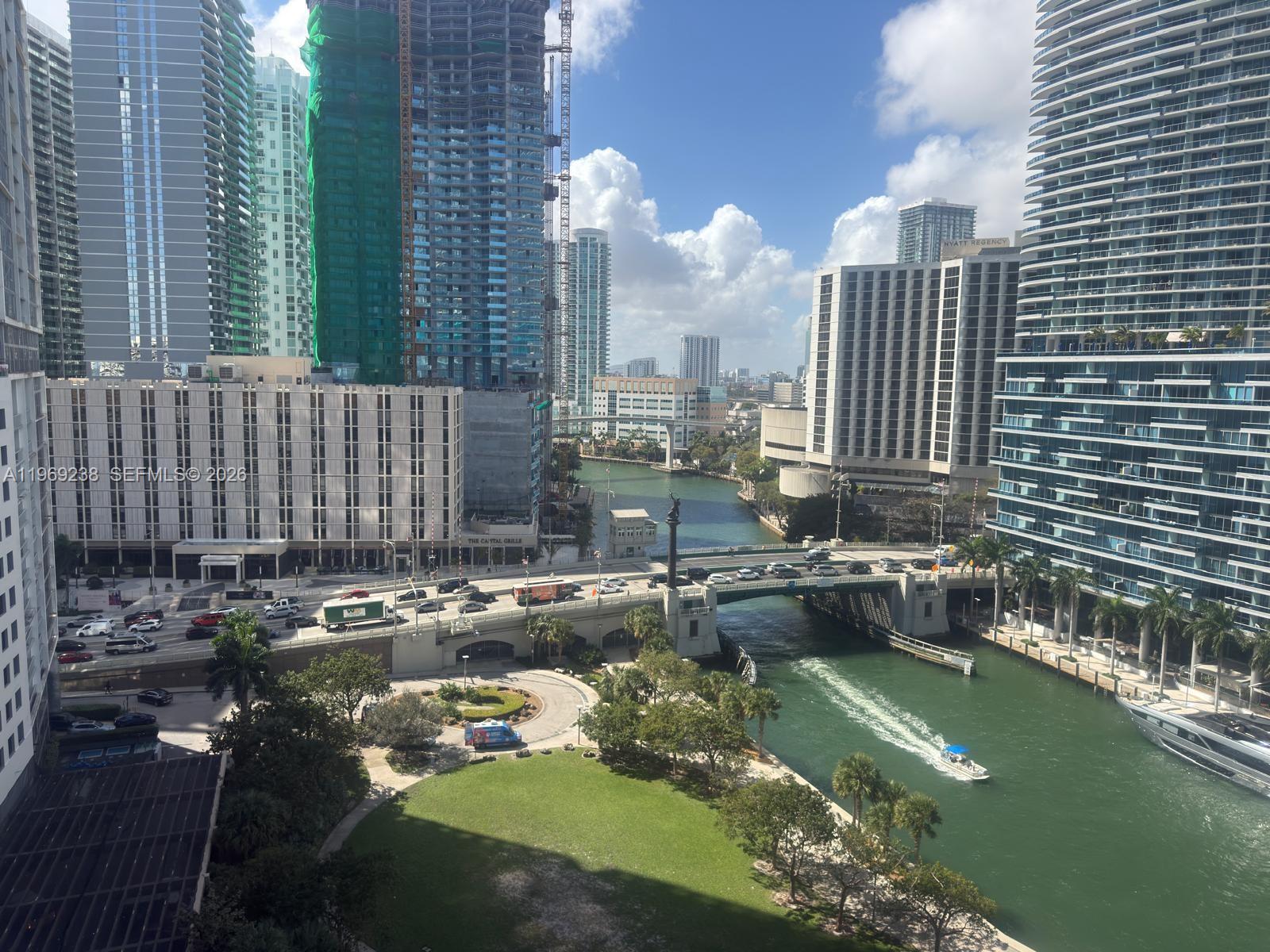 An elevated view of a city canal, a bridge with traffic, and surrounding high-rise buildings — 465 Brickell # 1504, Miami FL 33131, MIAMI, FL