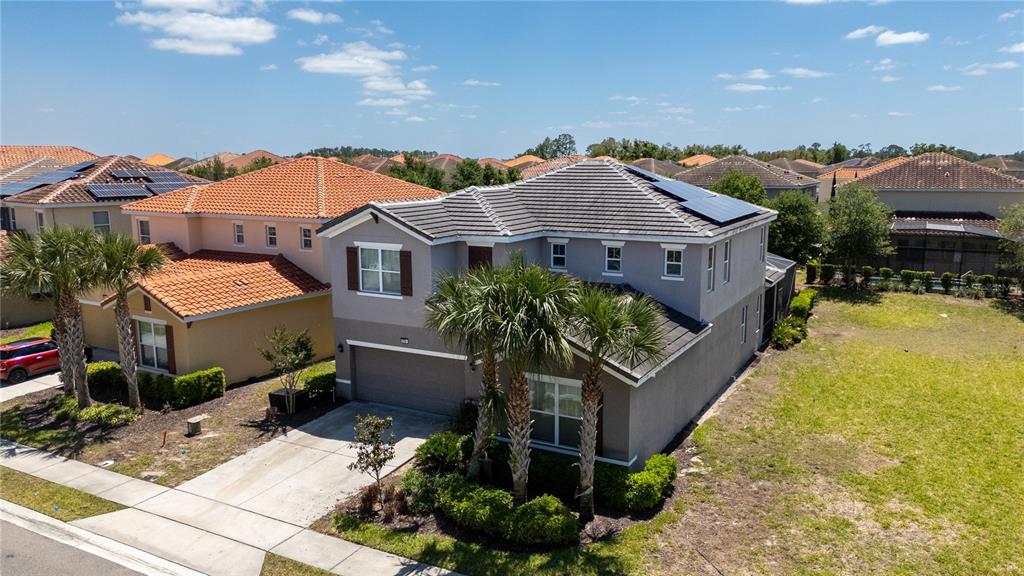 An aerial view of a two-story gray house with a tiled roof and solar panels — 6049 BROAD OAK DRIVE, DAVENPORT, FL