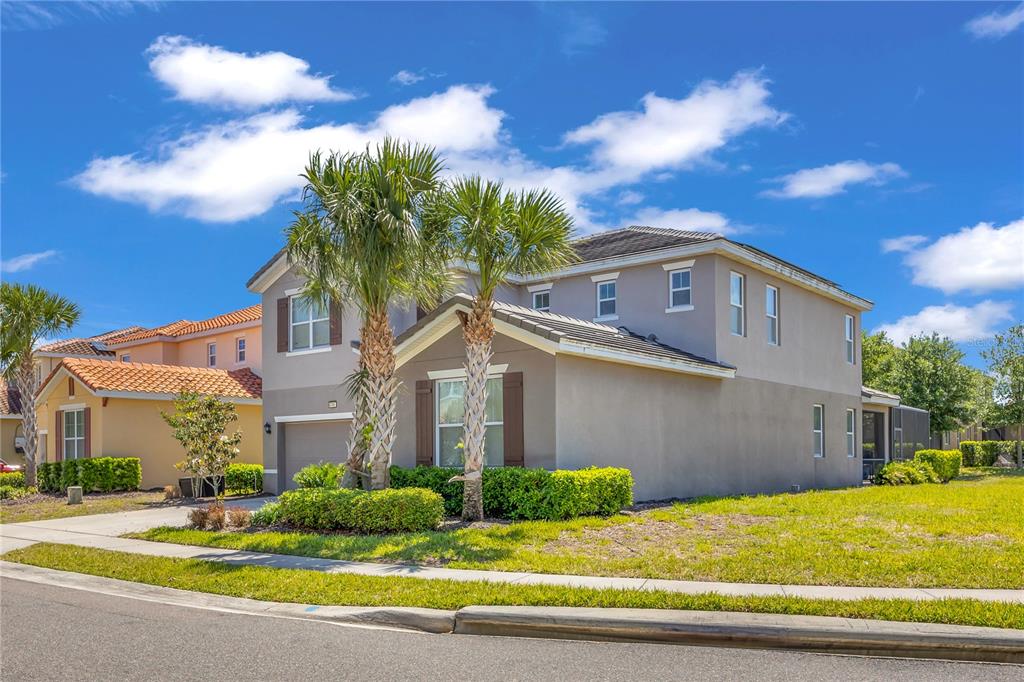 A two-story suburban house with a gray stucco exterior and two palm trees in front — 6049 BROAD OAK DRIVE, DAVENPORT, FL