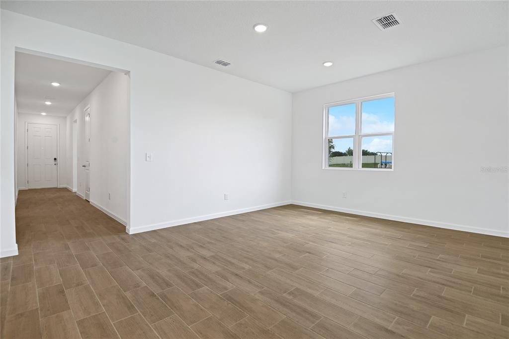 An empty room with light-colored walls, recessed lighting, and wood-look tile flooring — 6196 SW 64TH TERRACE, OCALA, FL